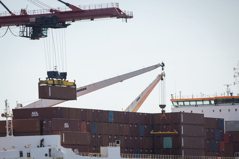 A shipping container is loaded onto a cargo ship at the New York Container Terminal...