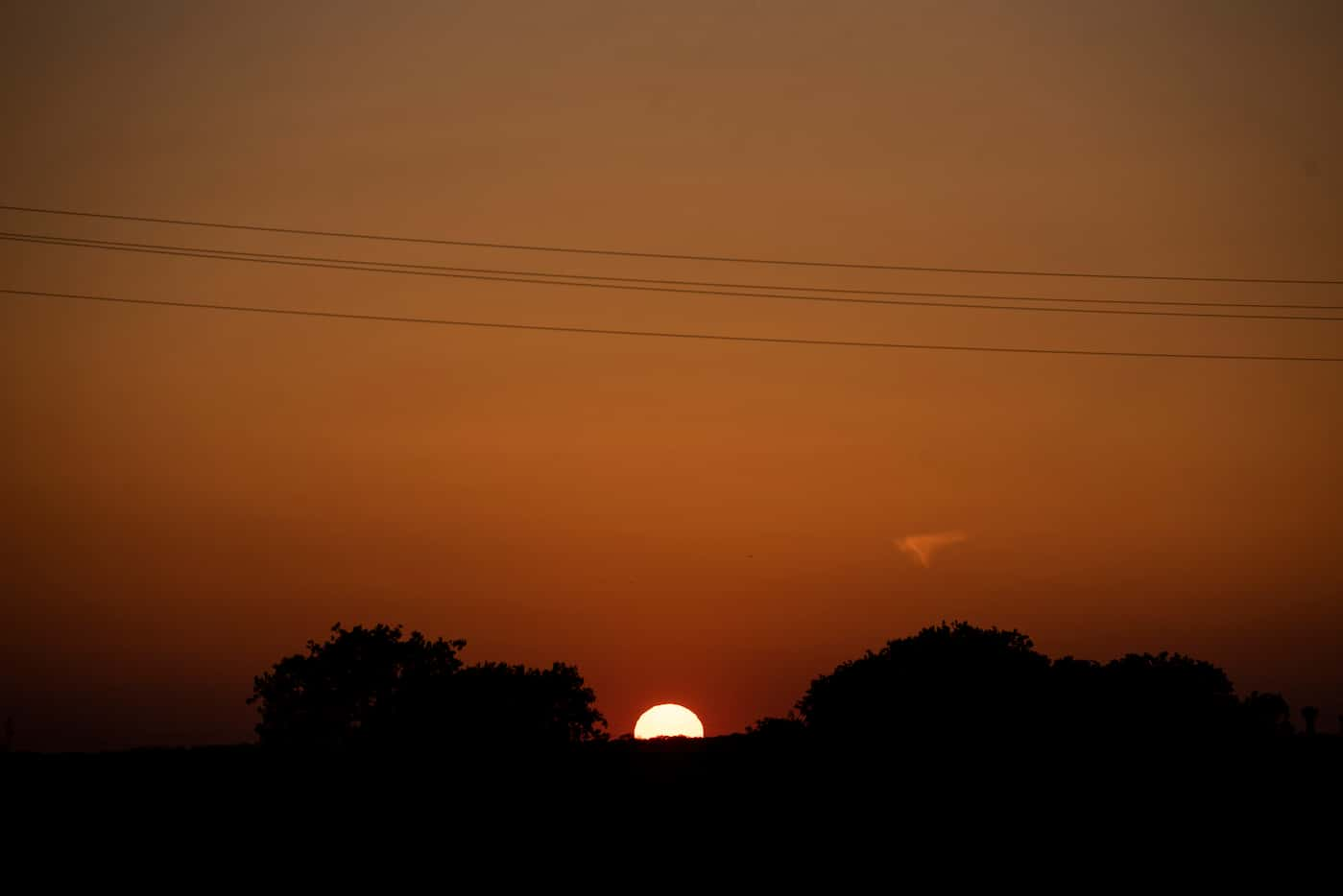 The sun sets during a baseball game between Crandall High School and Forney High School at...