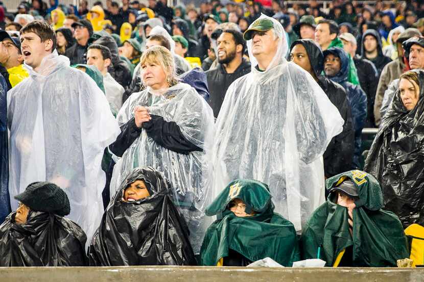 Baylor Bears fans huddle against the rain as they watch during the second half of loss to...