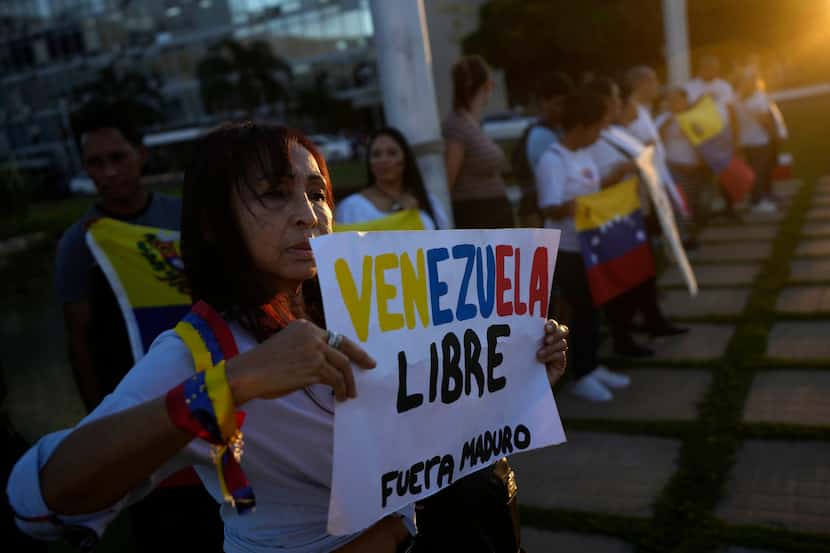 En la imagen, una ciudadana venezolana sostiene un cartel con un mensaje durante una...