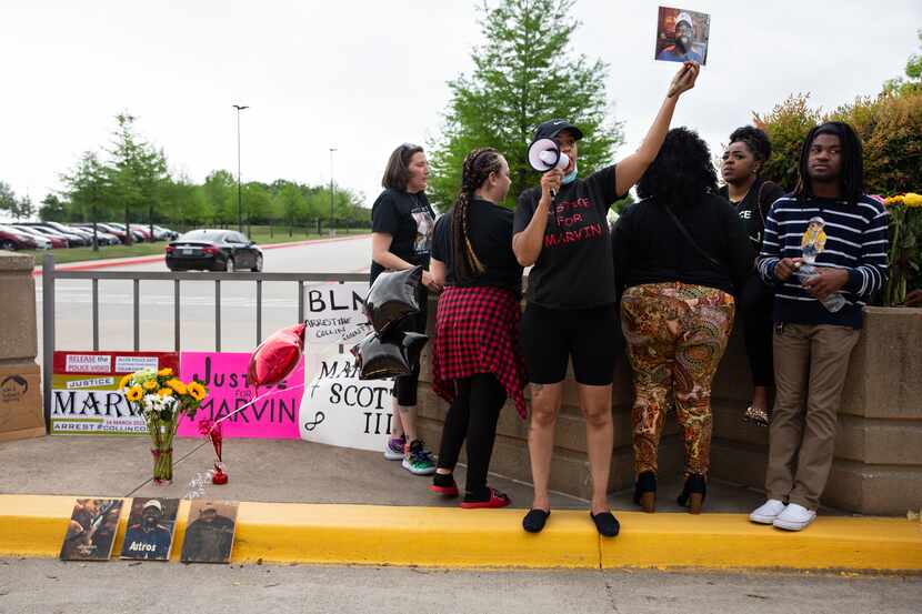 Renee White holds up a photo of Marvin Scott III while demanding the officers at the Collin...