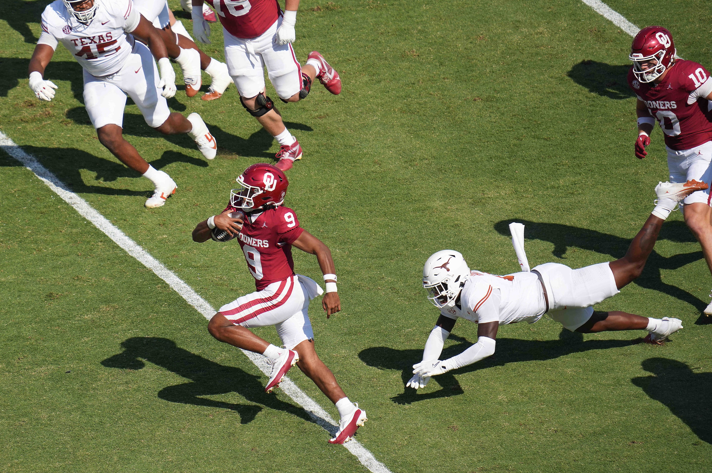 Oklahoma quarterback Michael Hawkins Jr. (9) gets past Texas linebacker Anthony Hill Jr. (0)...