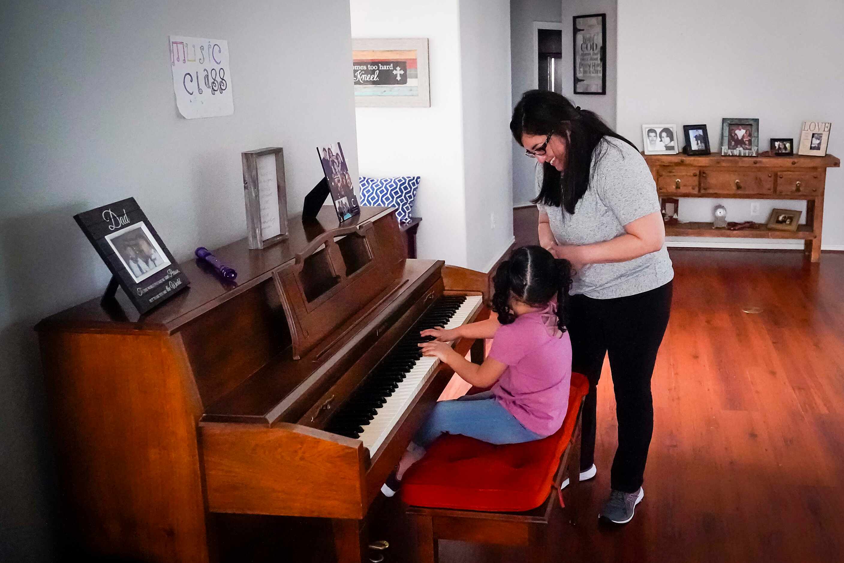 Nancy Segovia-Cabrera encourages her daughter Kamila Cabrera, 4, as she plays the piano at...