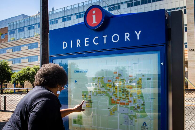  A woman consults a campus map of the University of Texas at Arlington on her way to meet...
