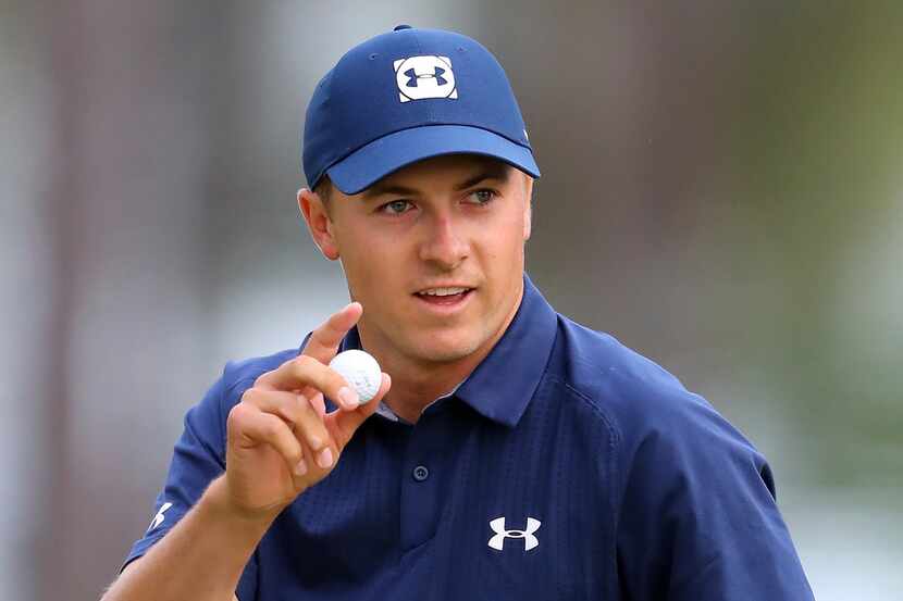 Jordan Spieth waves after making a birdie putt on the 16th hole during the first round at...