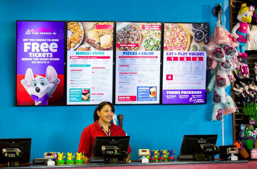 
Employee Adrianna Morales stands at the counter in front of a new digital menu board at...