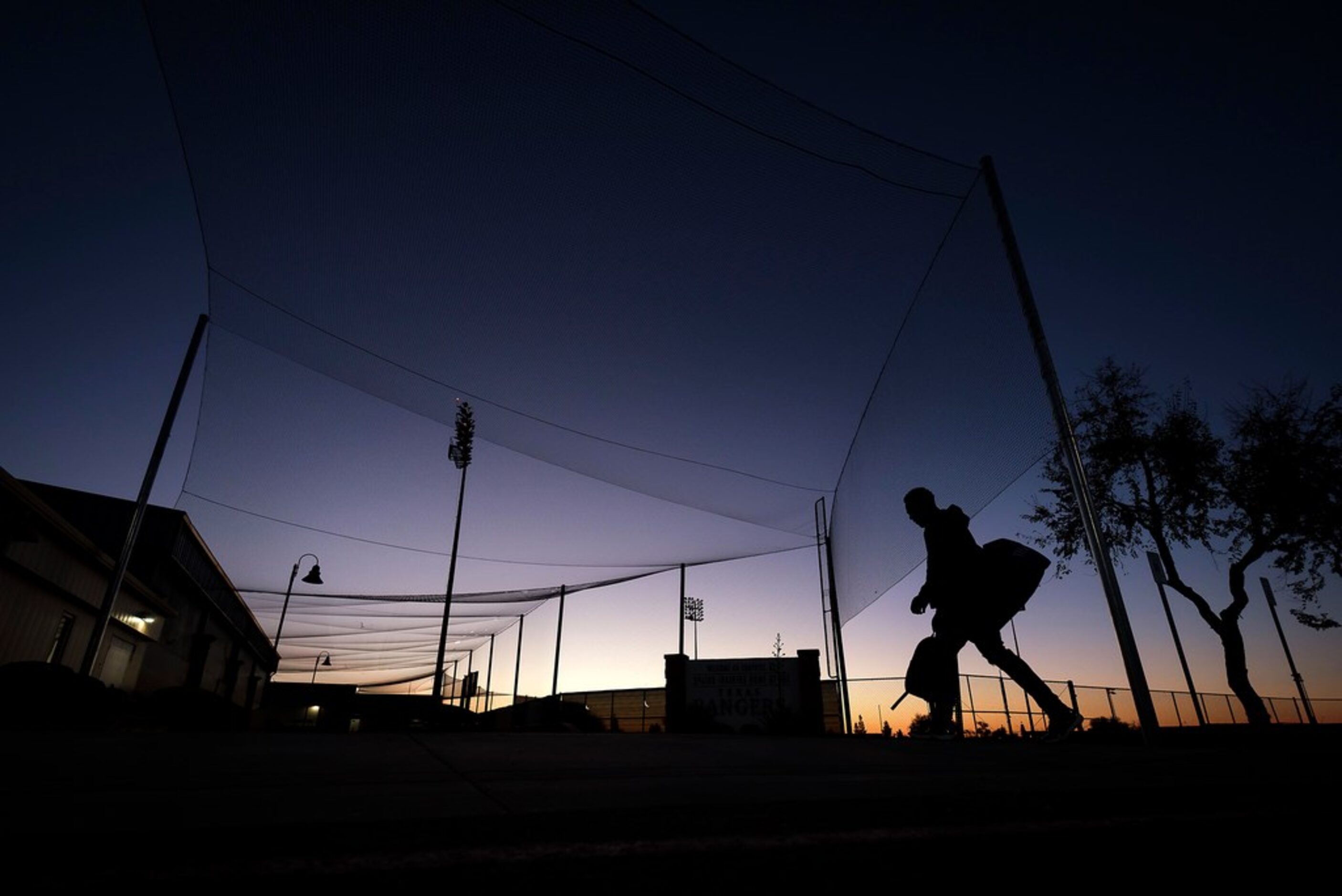 Texas Rangers pitcher C.D. Pelham heads toward the clubhouse as he arrives  before sunrise...