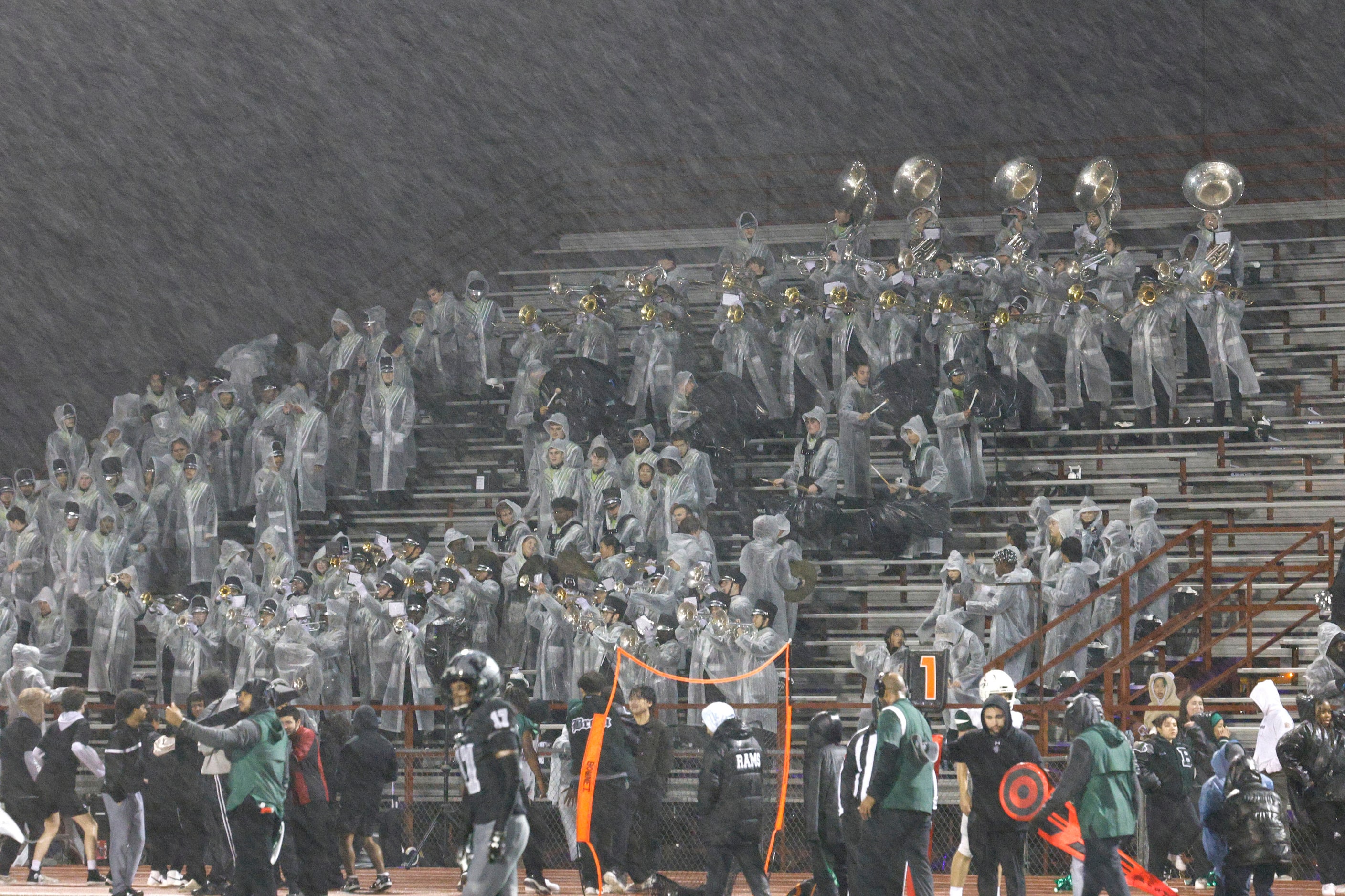 The Berkner High School Mighty Ram Band members play in the rain during the second half of a...