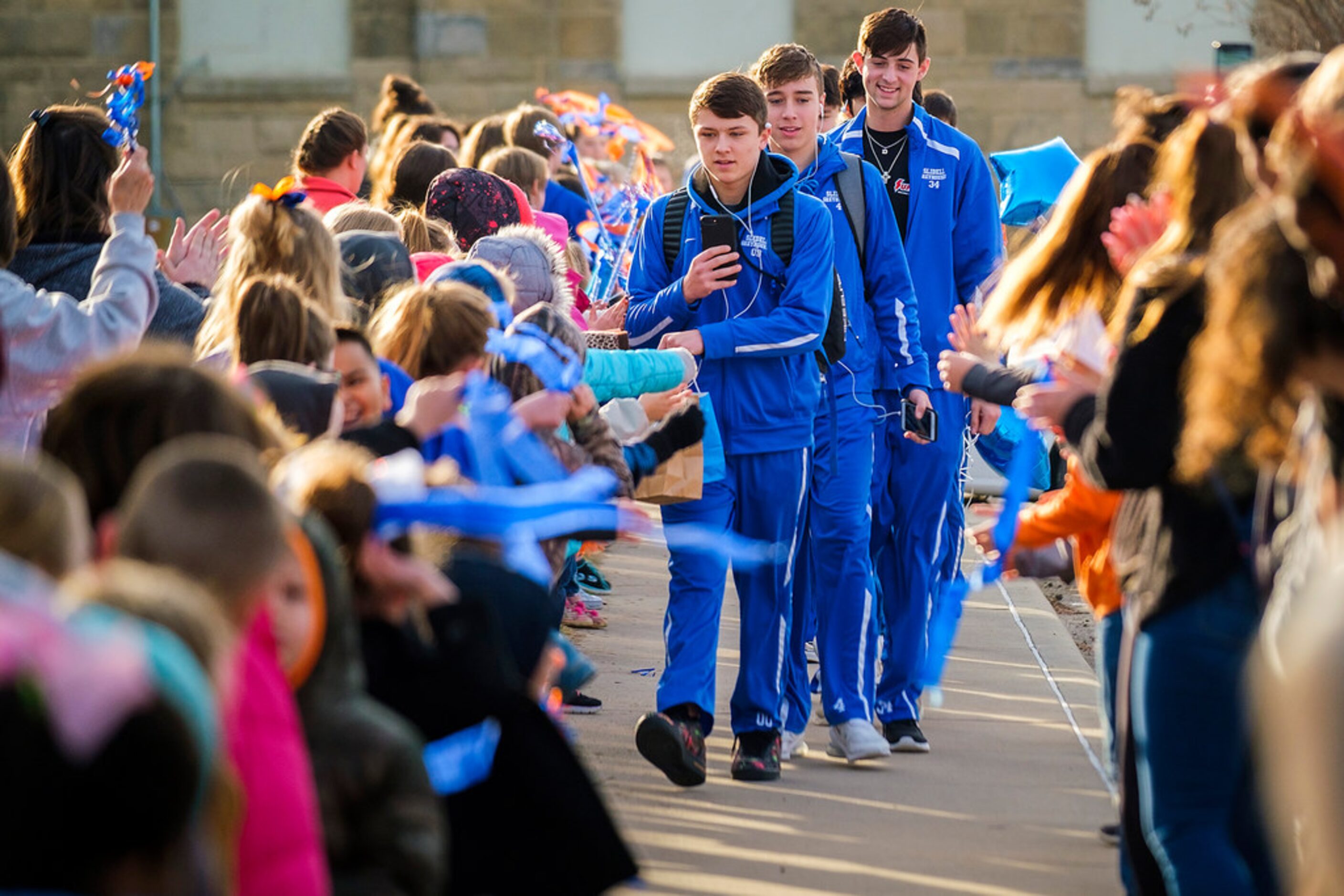 Students from K-12 line the sidewalk as Slidell guard Brock Harwell leads his teammates to...