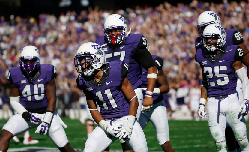 TCU cornerback Ranthony Texada (11) celebrates with teammates after he intercepted the ball...