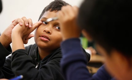 Then-seventh-grader Miles Goltl listened to a classmate as they worked on a city brochure...