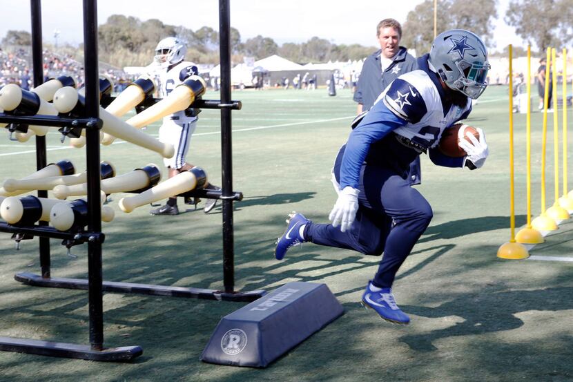 Dallas Cowboys running back Ezekiel Elliott (21) runs through a drill during the afternoon...