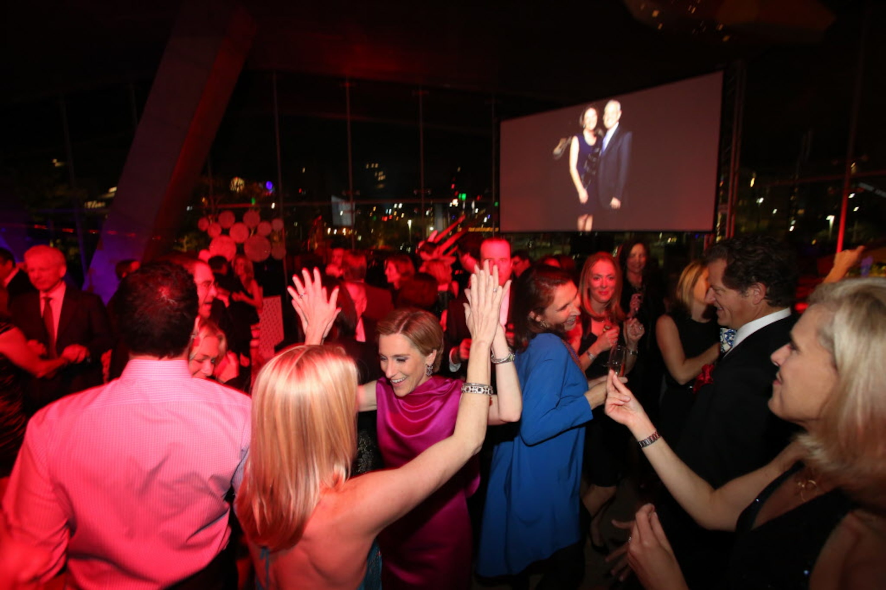 Nicole G. Small (center, wearing pink), the museum's chief executive officer, dances with...