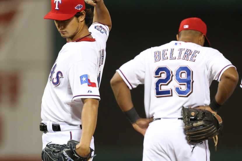 Texas Rangers starting pitcher Yu Darvish (11) stretches as he complained of stiff back in...