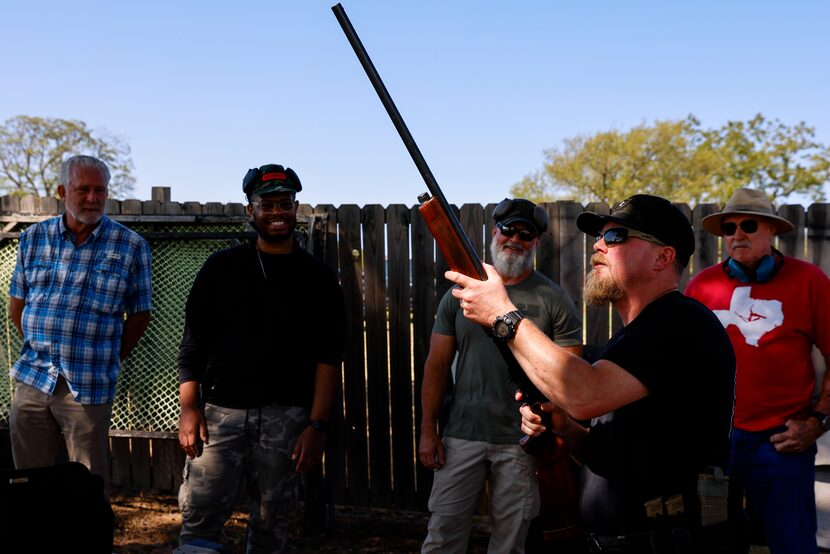 Senior instructor William Chadwick (front) examines the firearms before a firearm...