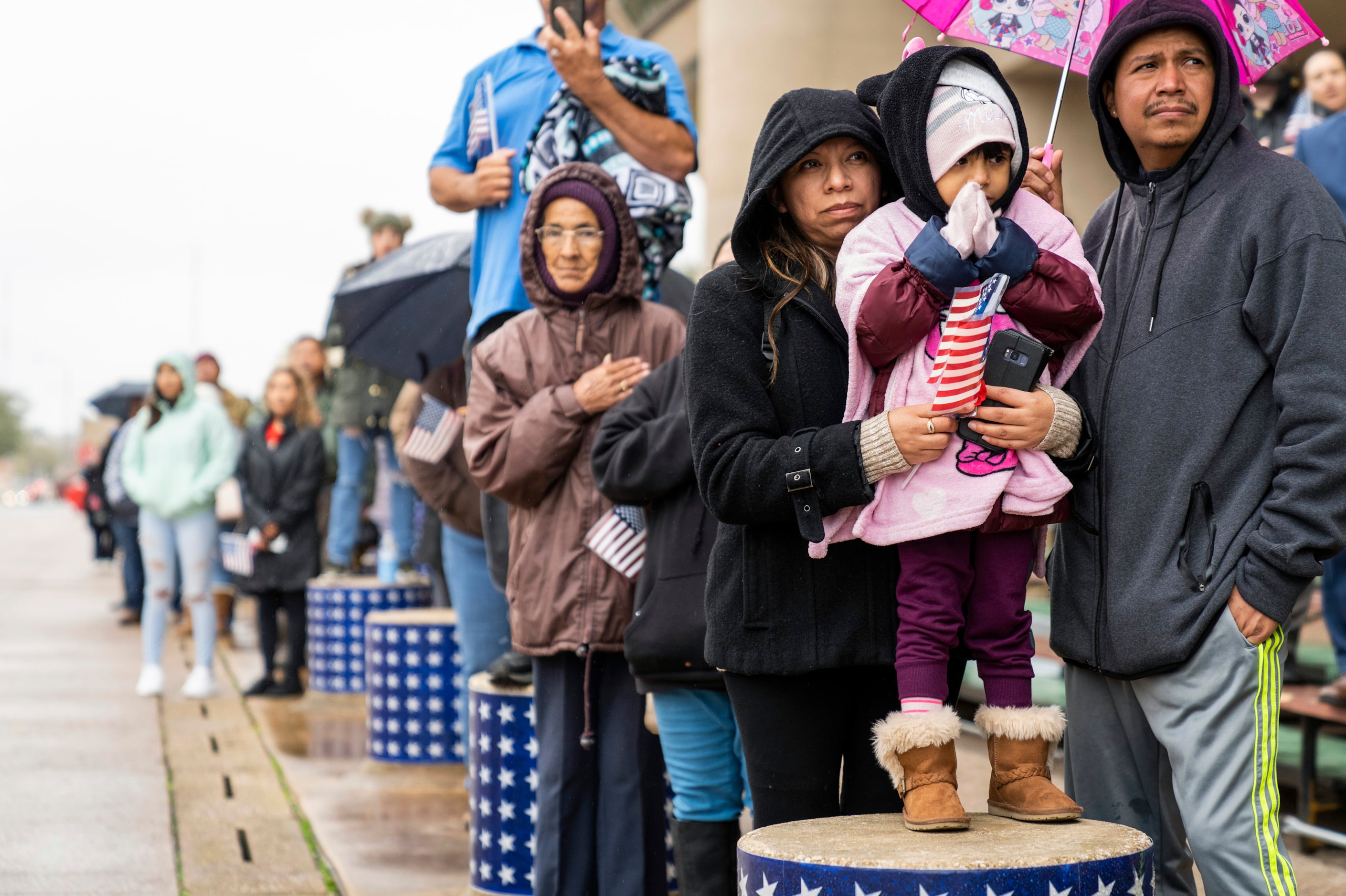 Spectators huddles against a cold drizzle at City Hall Plaza before The Greater Dallas...