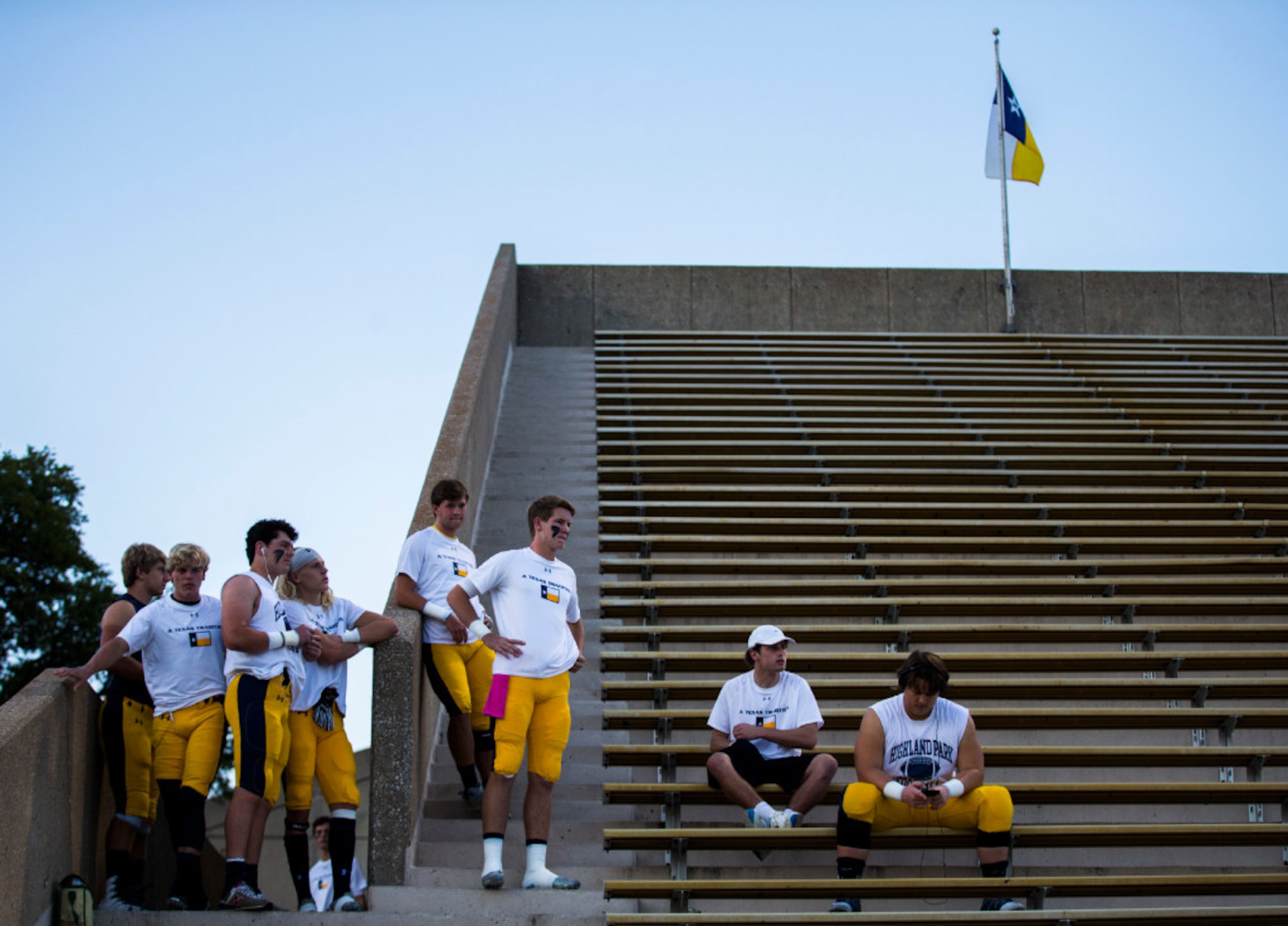 Highland Park football players watch from the stands as Mesquite Poteet players warm up on...