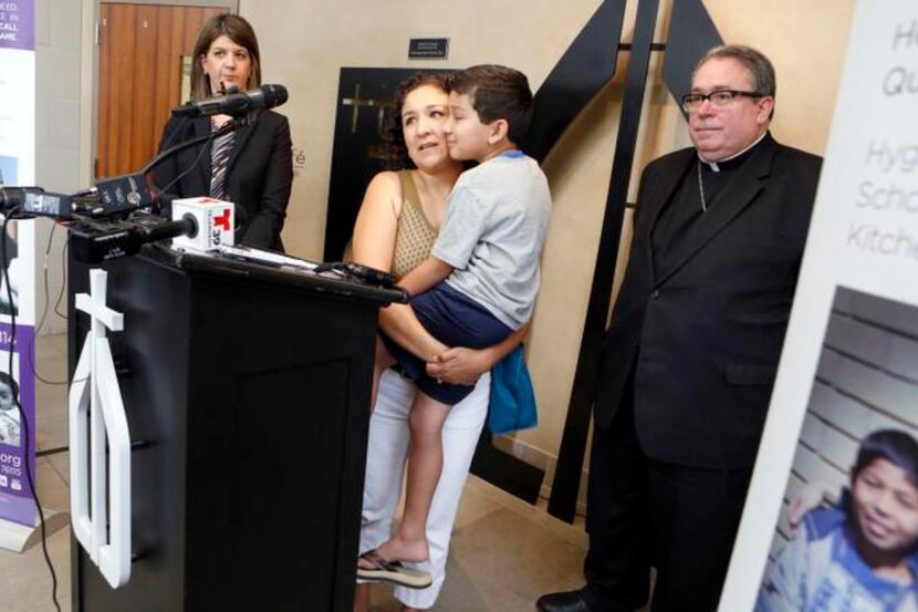 
Anamaria Mares and her son, Roman, talk with reporters at Catholic Charities in Fort Worth...