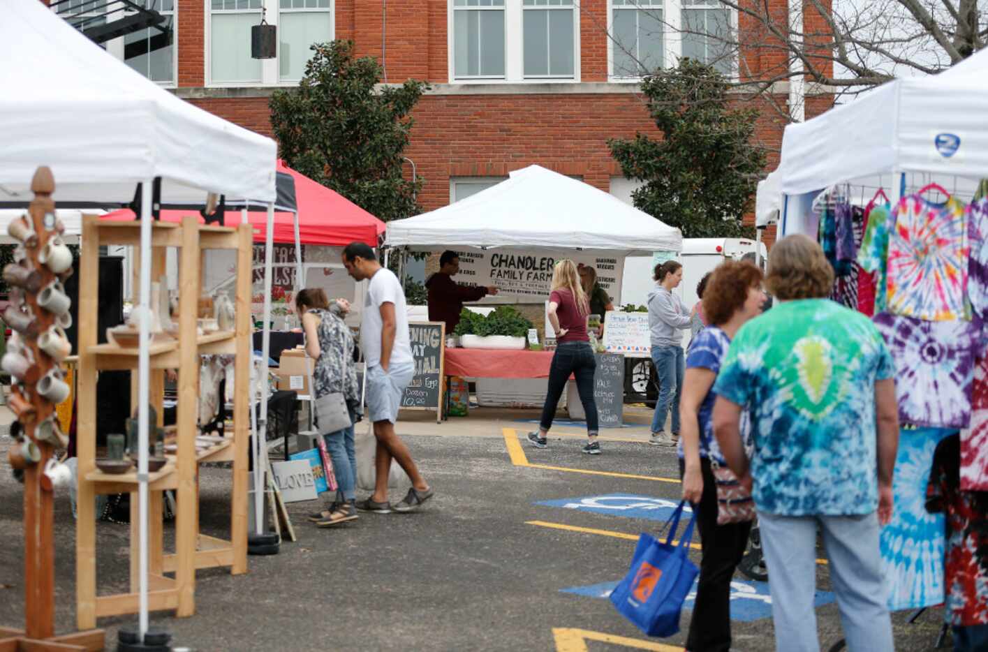 People shop from booth to booth during opening day of Tyler Street Farmers Market in Oak Cliff.