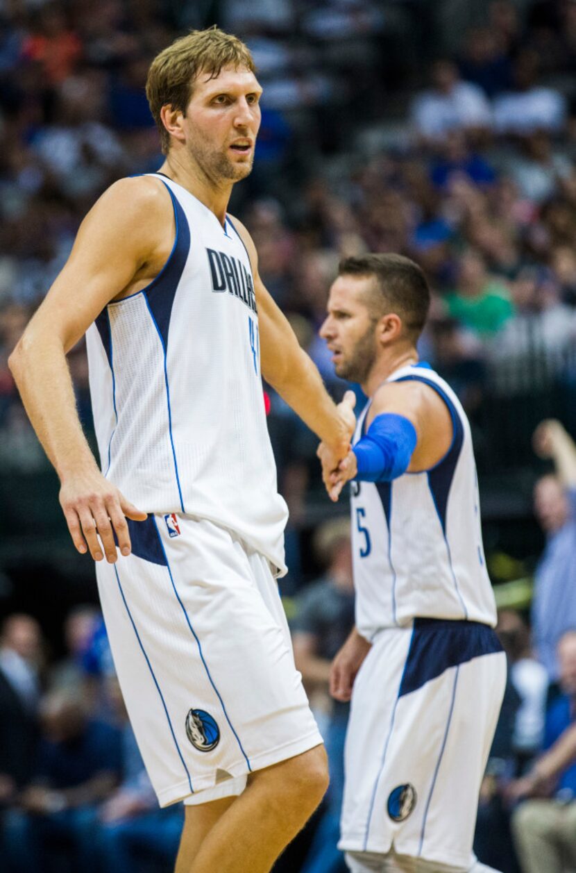 Dallas Mavericks forward Dirk Nowitzki (41) high fives guard J.J. Barea (5) after a point...