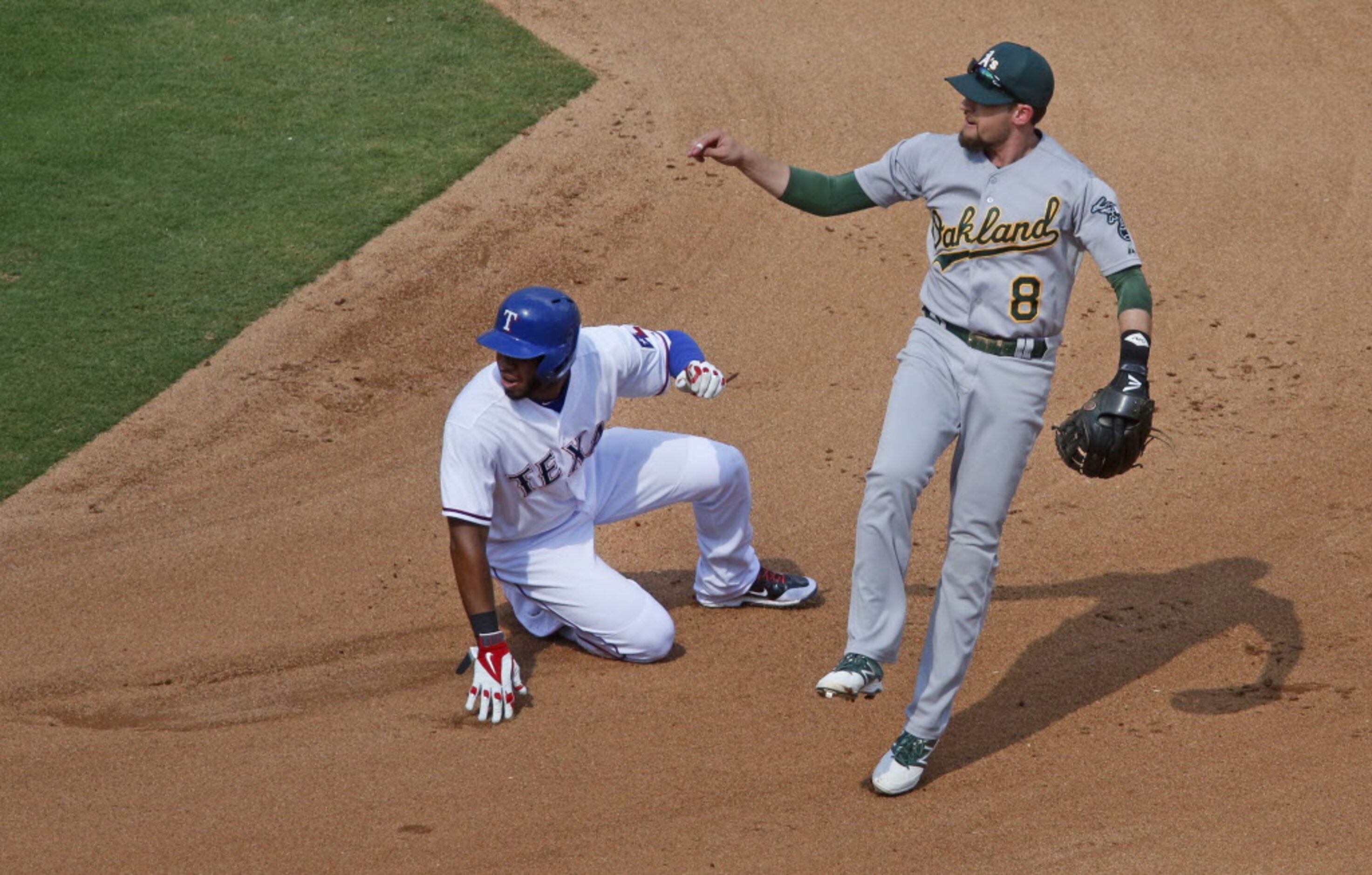 Oakland shortstop Jed Lowrie forces Texas' Elvis Andrus at second base in the fourth inning...