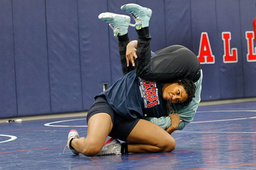 Allen High School senior Jasmine Robinson, bottom, works out with freshman Kailin Sebert...