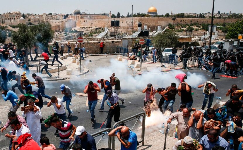 Palestinian worshippers ran for cover from tear gas fired by Israeli forces outside...