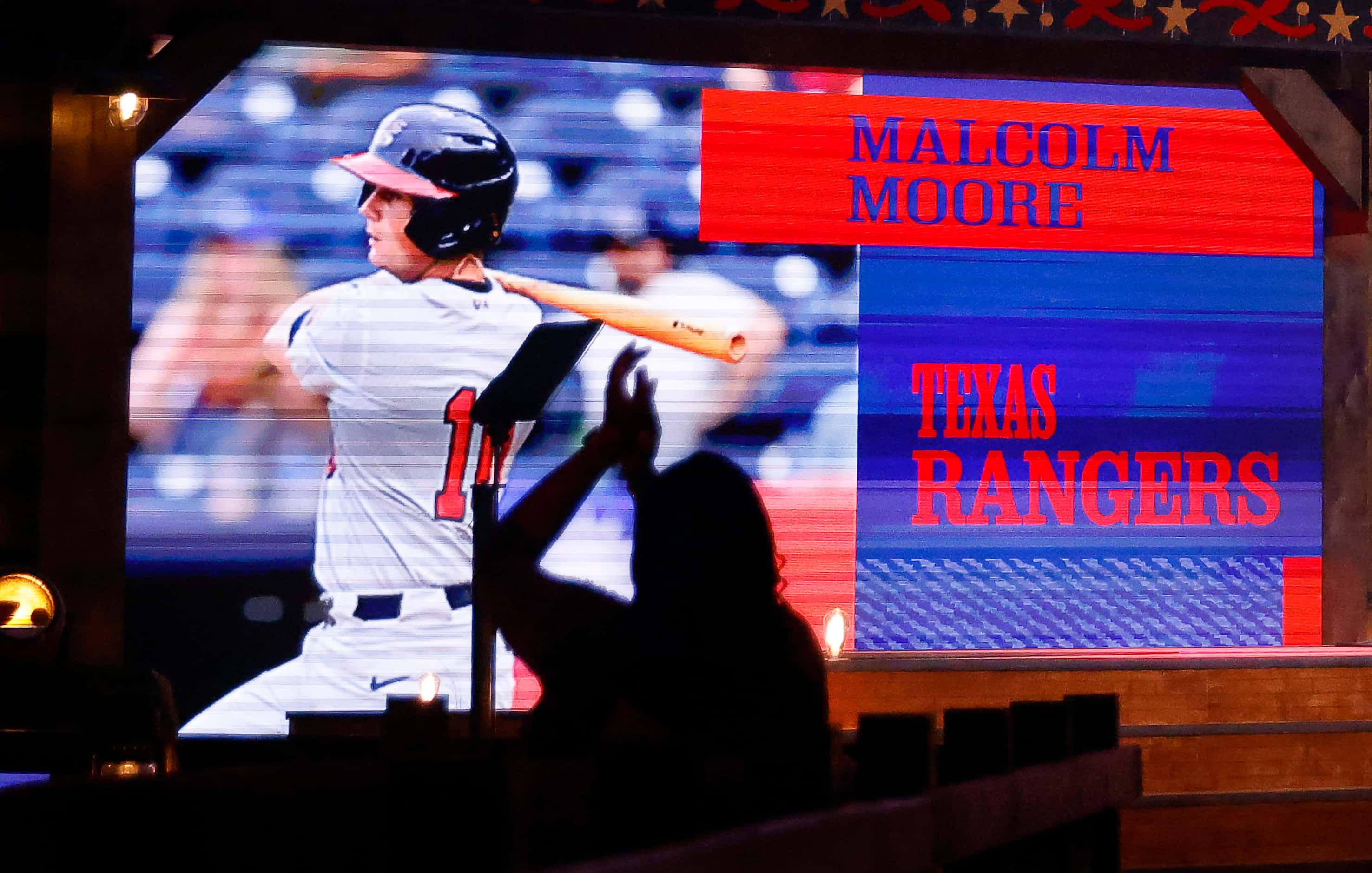 A fan applauds the Texas Rangers selection of Stanford catcher Malcolm Moore for the 30th...
