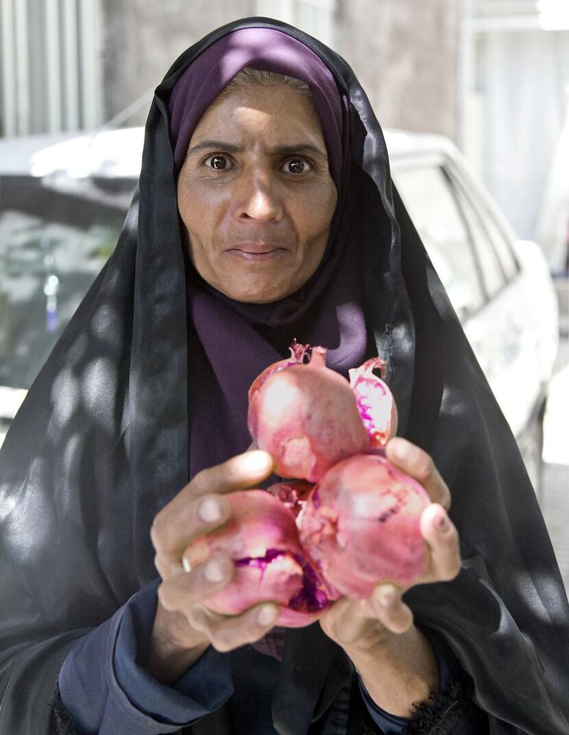 A villager in Mahan  offers freshly picked ripe pomegranates.