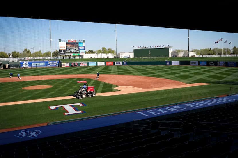 Groundskeepers work on the field at Surprise Stadium in preparation for the Texas Rangers...