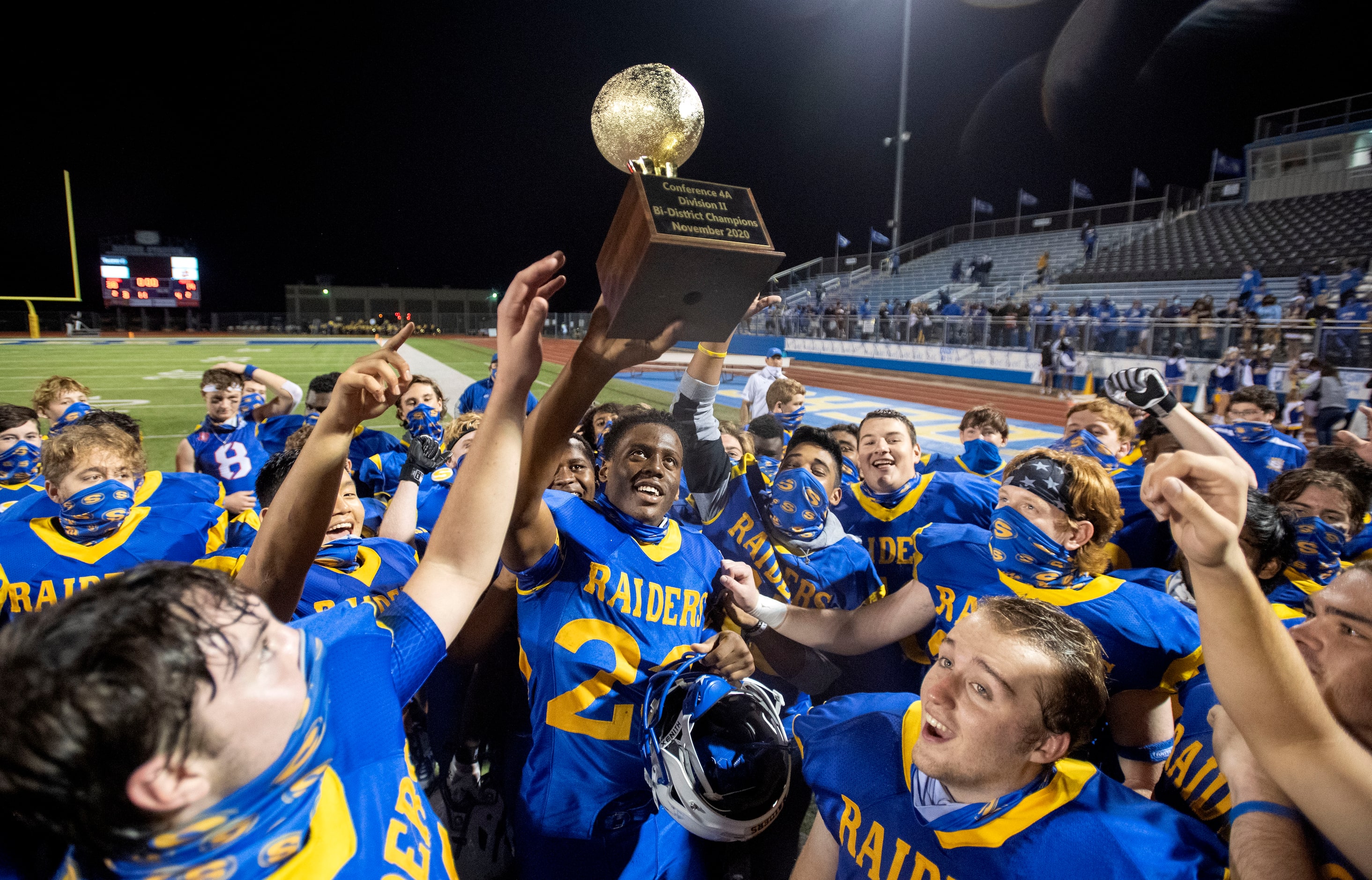 Sunnyvale senior running back Obi Arinze (23) hoists the trophy after his team beat Ferris...