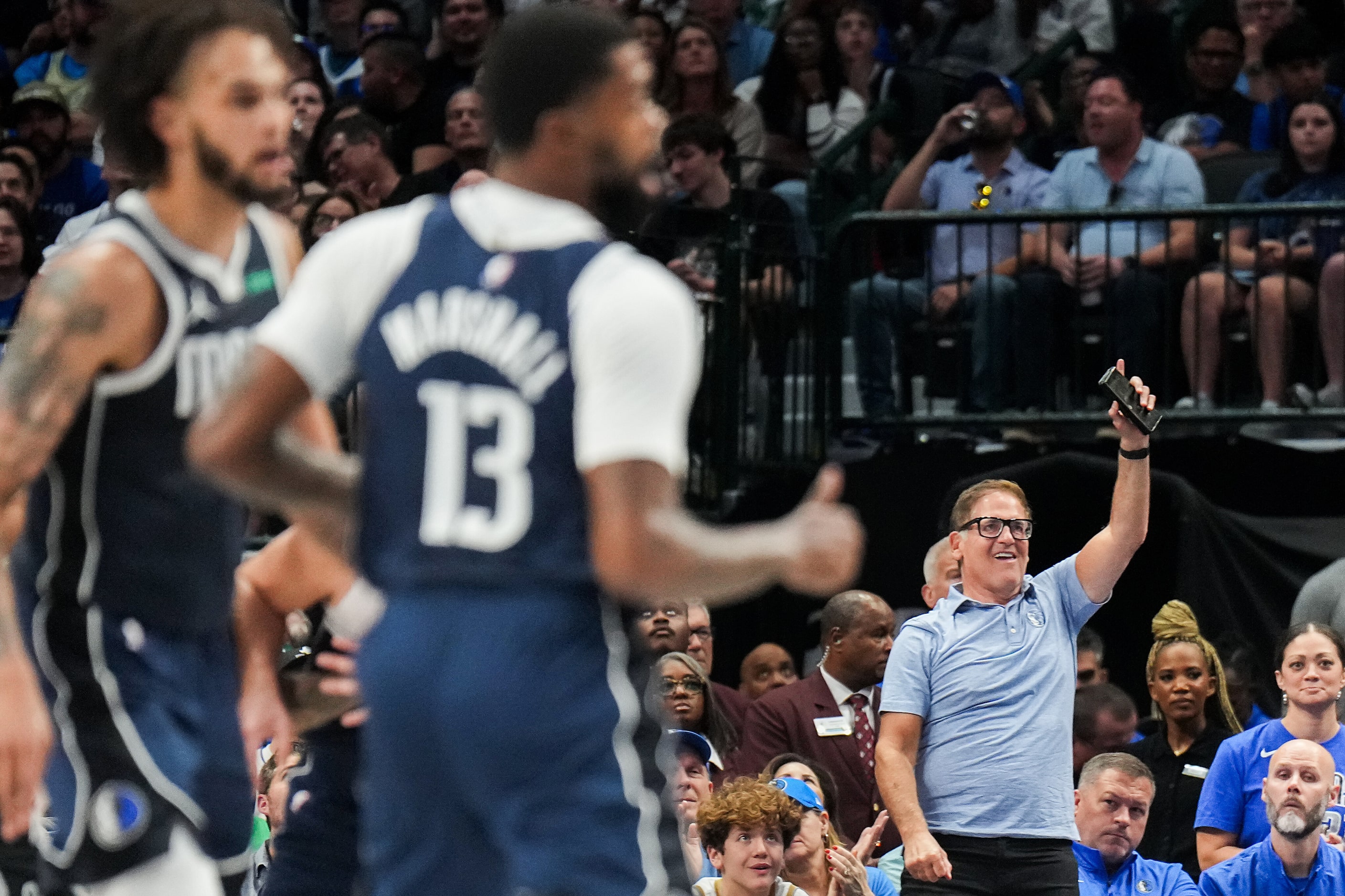 Mark Cuban cheers a Dallas Mavericks basket during the first half of an NBA basketball game...