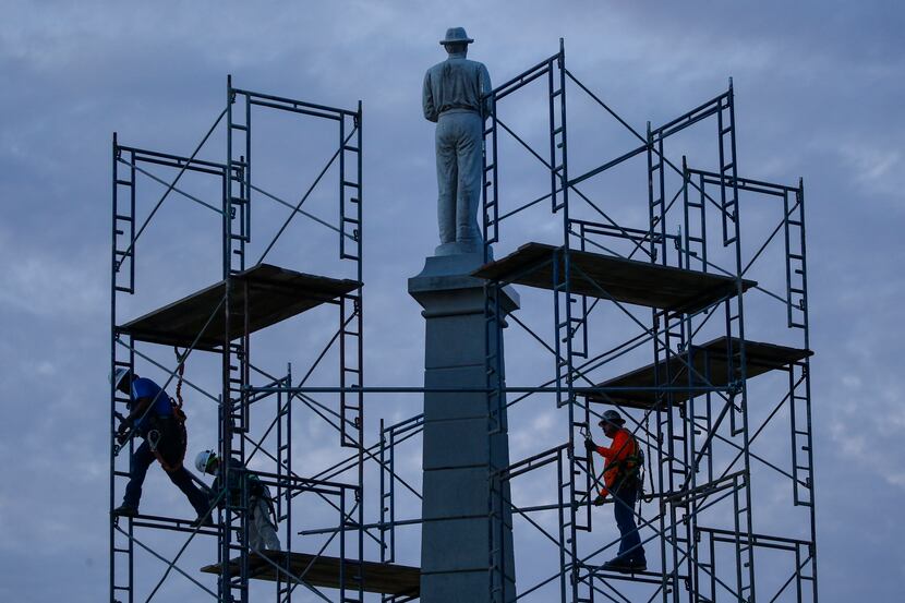 In this June 24, 2020, file photo, construction workers remove the final soldier statue,...