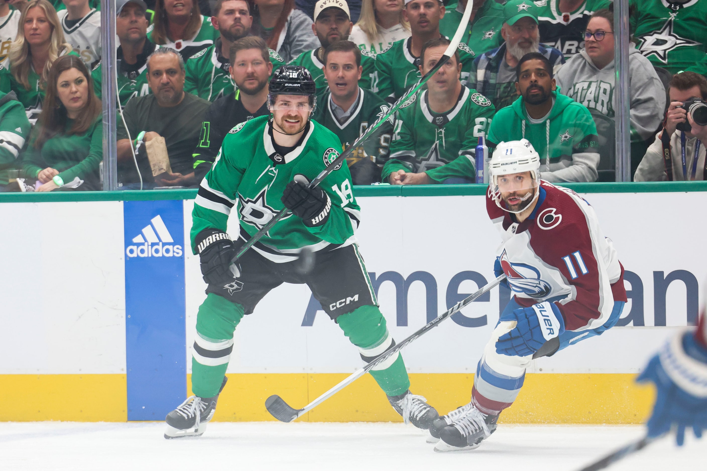 Dallas Stars center Sam Steel (left) follows as he passes the puck past Colorado Avalanche...