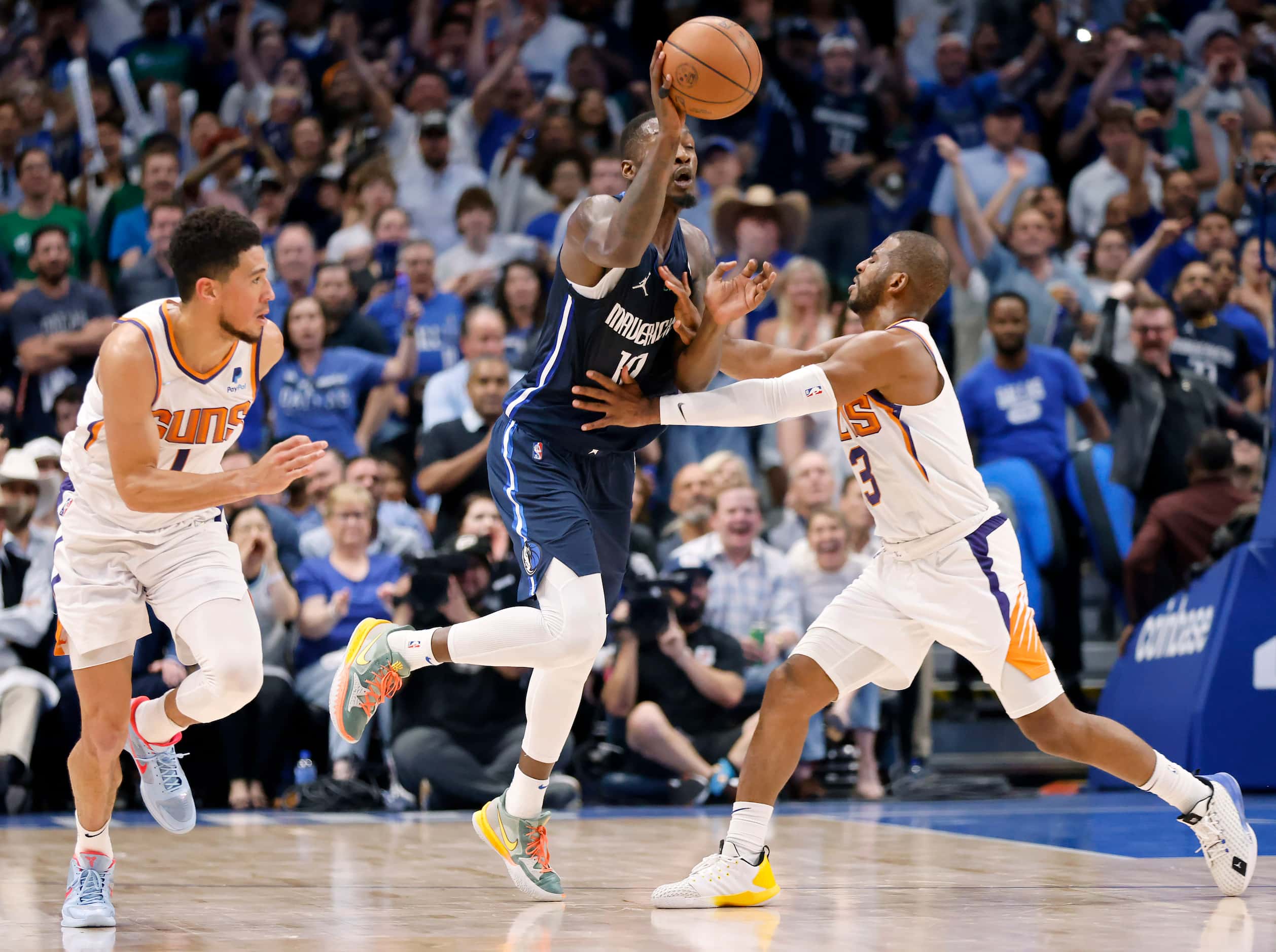 Dallas Mavericks forward Dorian Finney-Smith (10) is fouled by Phoenix Suns guard Chris Paul...