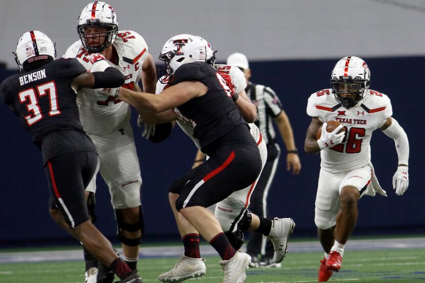 Texas Tech running back Ta'Zhawn Henry (26) explores a running lane provided by offensive...