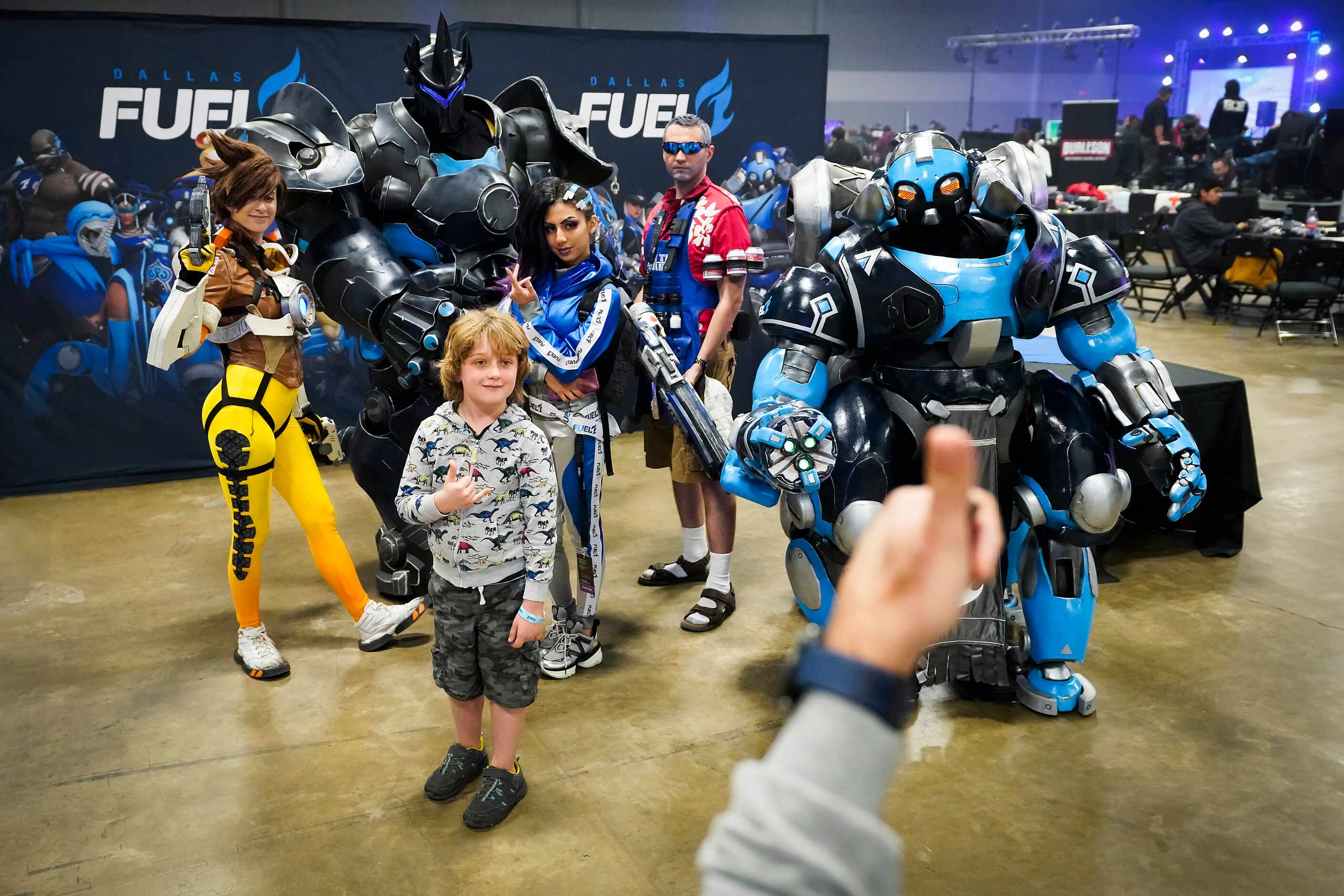 Noah Scholz poses for photos with cosplay characters in the Dallas Fuel opening weekend fan...