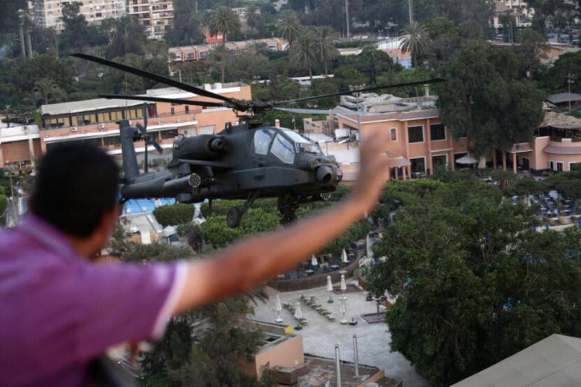 Egyptian military attack helicopter flies by the Presidential palace, in Cairo Friday. Army...