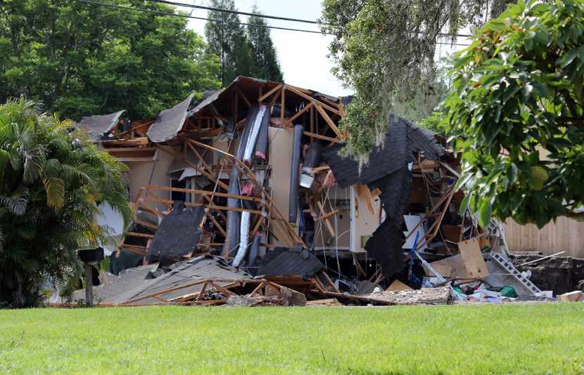 Debris is strewn about from a partially collapsed home in Land O' Lakes, Fla. (Alessandra da...