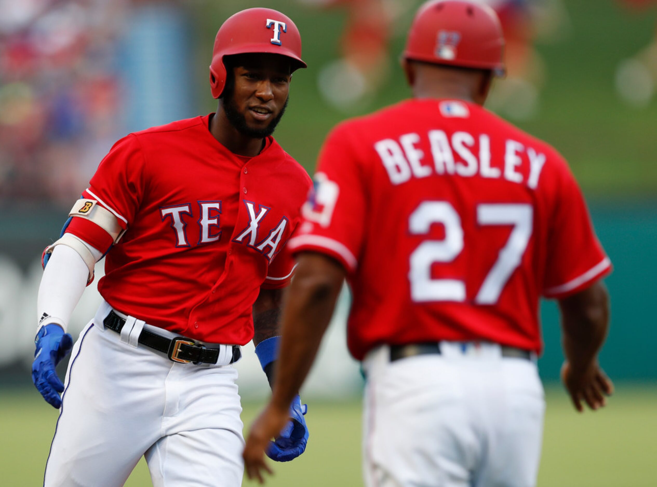 Texas Rangers' Jurickson Profar, left, celebrates his two-run home run with third base coach...