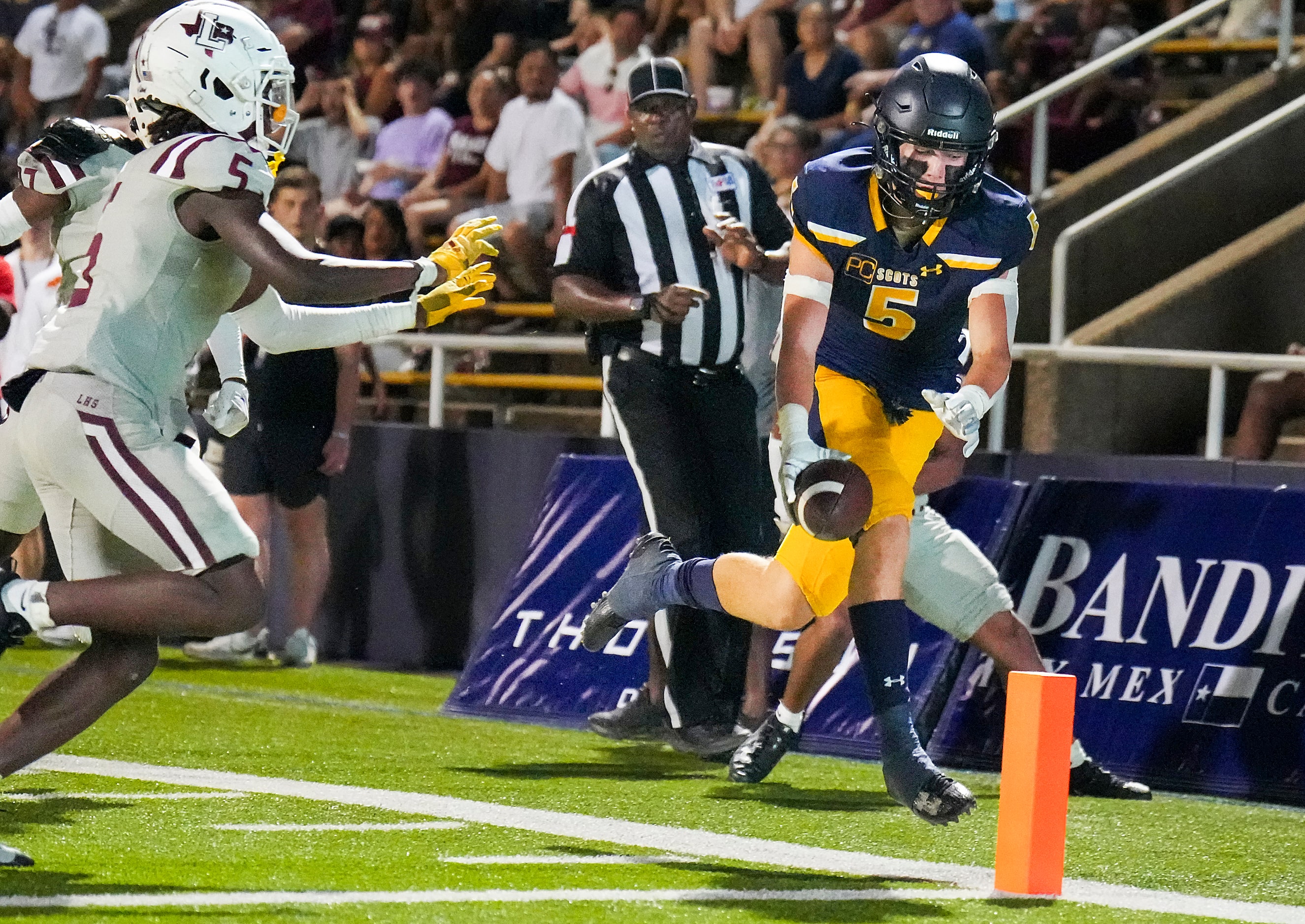 Highland Park running back Keller Holmes (5) scores past Lewisville defensive back...