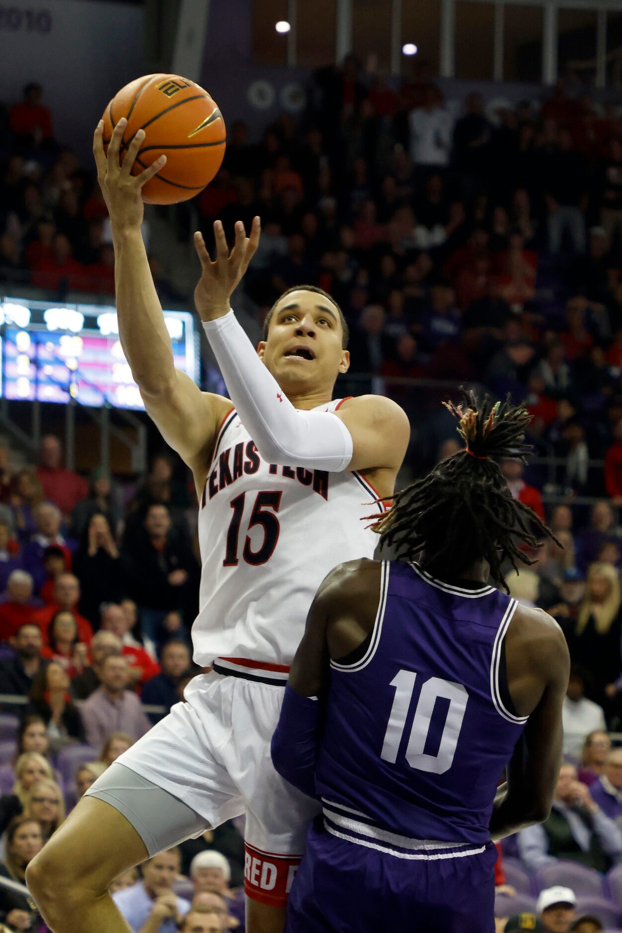 Texas Tech guard Kevin McCullar (15) scores on TCU guard Damion Baugh (10) during the first...