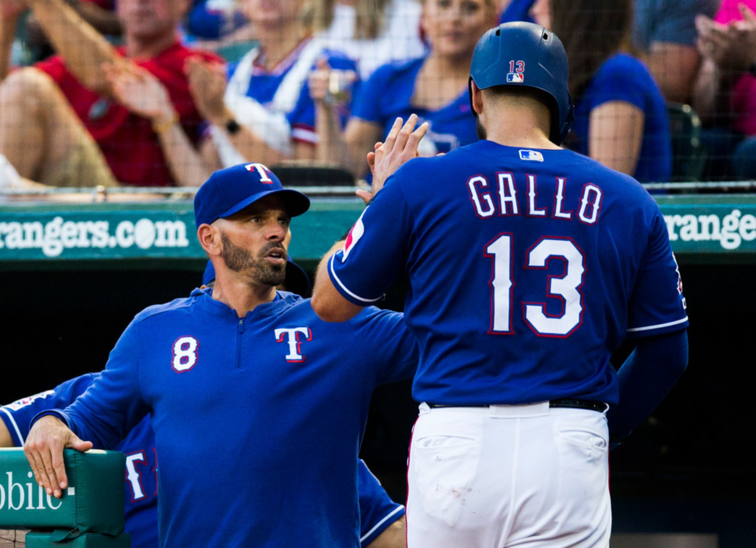 Texas Rangers center fielder Joey Gallo (13) gets a high-five from manager Chris Woodward...