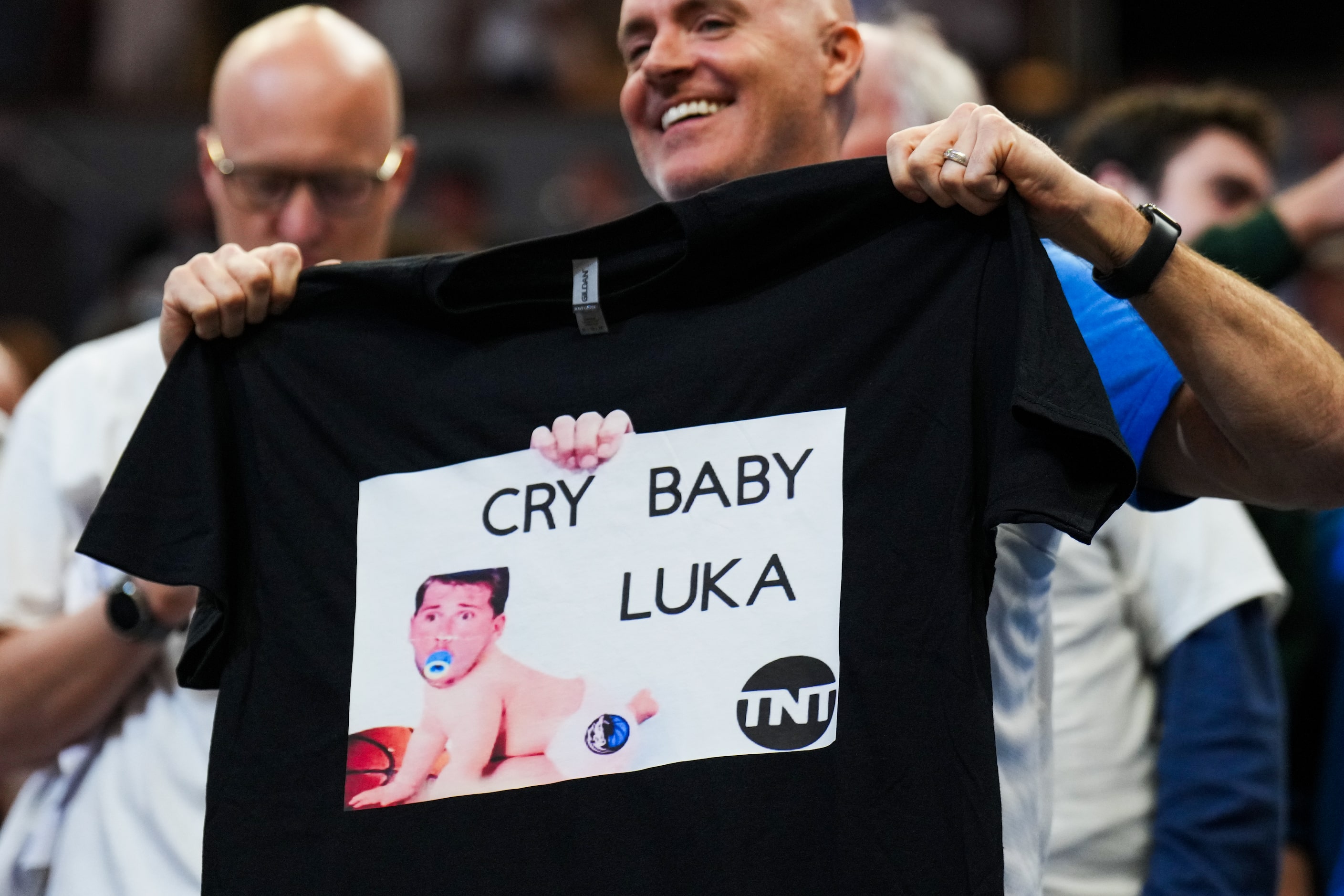 A Minnesota Timberwolves fan holds a t-shirt mocking Dallas Mavericks guard Luka Doncic...