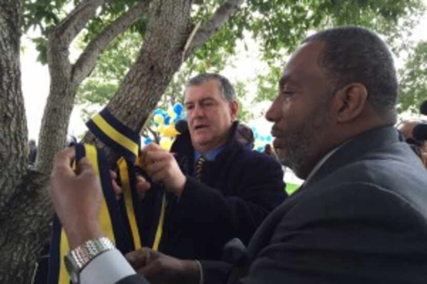  Dallas Mayor Mike Rawlings and State Sen. Royce West, D-Dallas, tie a blue-and-yellow...