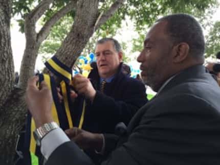  Dallas Mayor Mike Rawlings and State Sen. Royce West, D-Dallas, tie a blue-and-yellow...