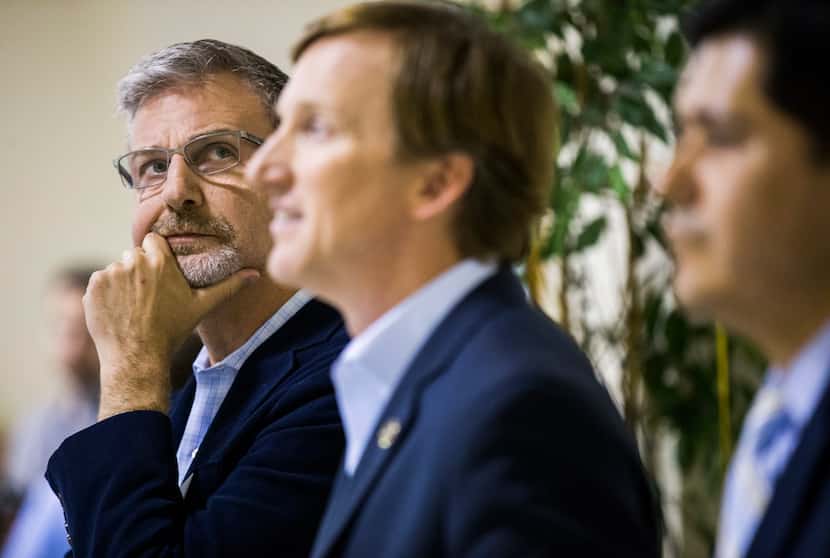 Gubernatorial candidate Jeffrey Payne, left, looks up as he, Andrew White, center, Adrian...