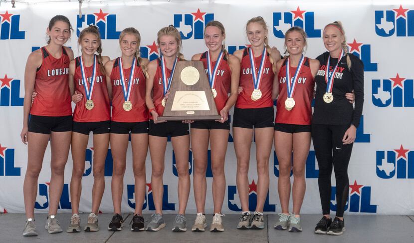 Members of the Lovejoy cross country team pose with medals and the state championship trophy...