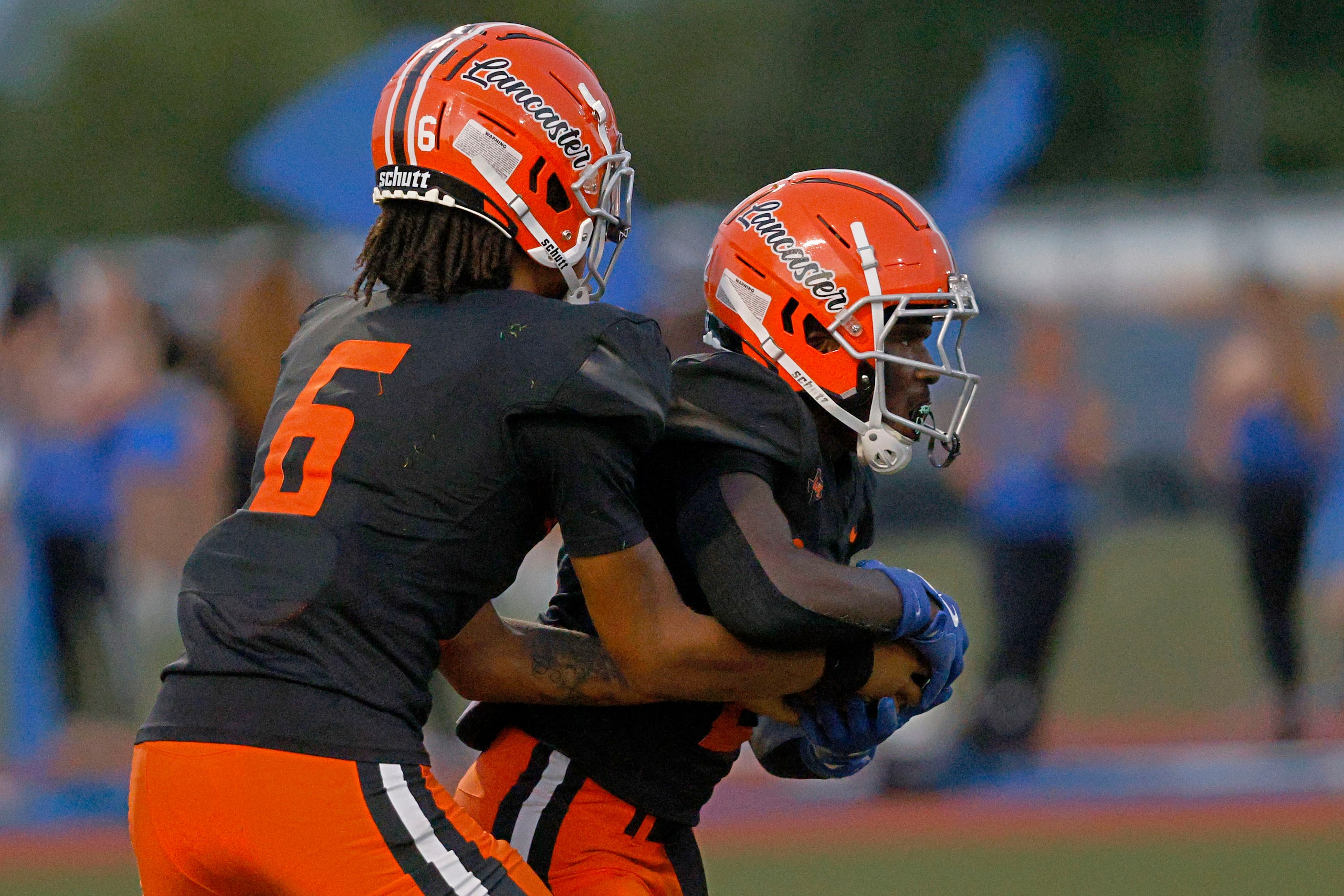 Lancaster’s quarterback Carter Jones  hands off to Lancaster’s Izayah Lee (2), right, in the...