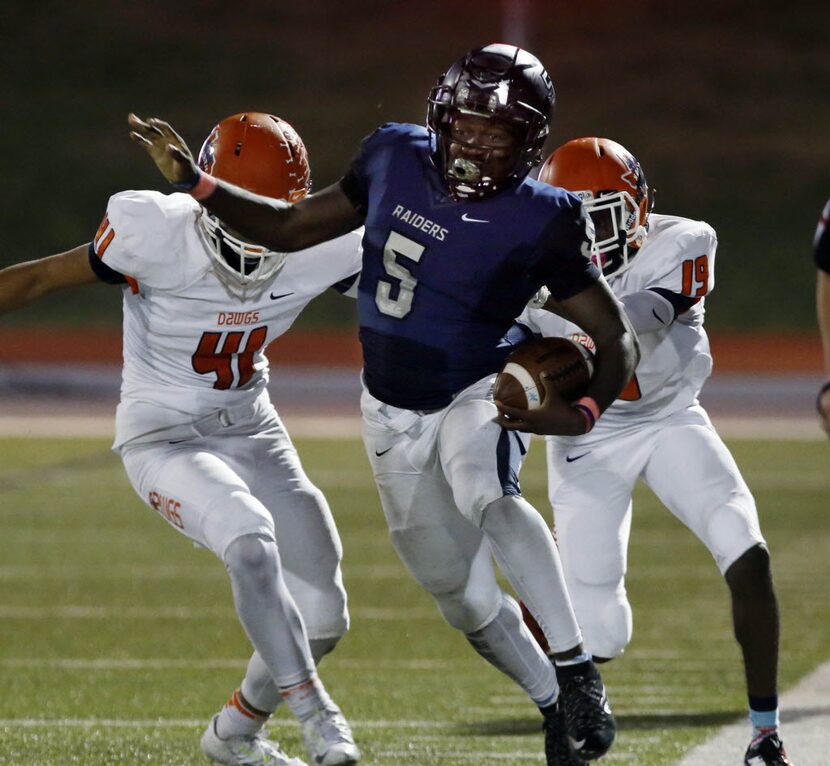 (TXHSFB) Wylie East's Eno Benjamin (5) escapes momentarily from Mckinney North defenders...